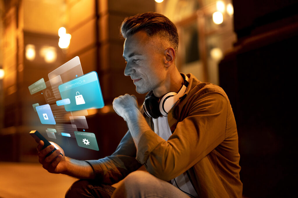 a man sitting on the ground looking at a device